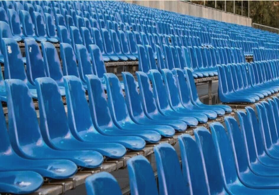 Echtes Foto einer bestuhlten Zuschauertribüne mit Reihen blauer Sitzschalen — reales Projektbild von Event Visuell